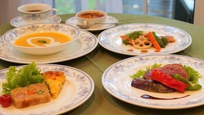 A table with four plates of food, each with different dishes. - Winds (Tateshina)