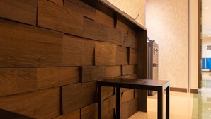 Un mur orné de panneaux en bois, une table noire et une porte à l’arrière-plan.