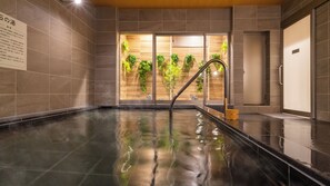 A spa pool with a glass wall, a wooden bench, and a sign on the wall. - Super Hotel Yahaba Station East (Yahaba)