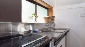 Cozinha com fogão, pia e barril de madeira.