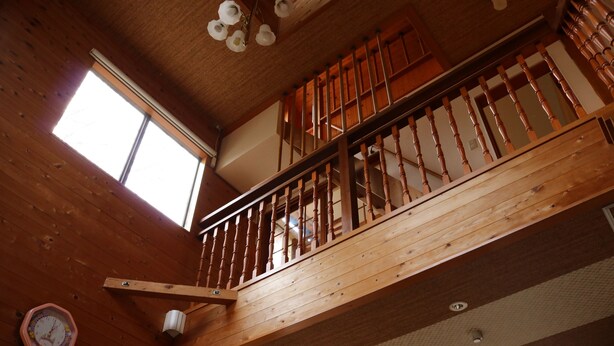 A wooden interior with a staircase, a window, and a wall-mounted clock. - Heartland Hills in Noto 5 Ike no Hotori House (Shika)