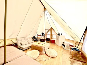 A tent with a bed, a sofa, a small table, and a chair. - Kabuku Resort (Shima)