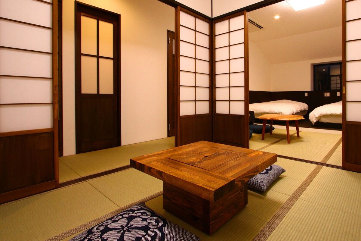 A traditional Japanese-style room with tatami flooring, a low wooden table, and shoji screens.