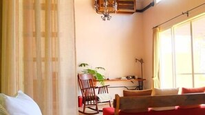 A bedroom with a bed, a rocking chair, a desk, and a window. - Somos (Nakijin)