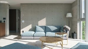 A modern living room with a sofa, two side tables, and a lamp. - Okinawa Plaisant Villa (Onna)
