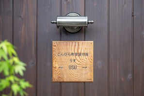 Une porte en bois avec une poignée en métal et une pancarte portant un texte en japonais.