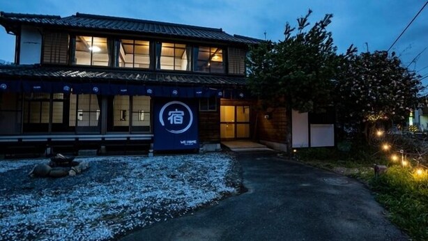 Un edificio in stile tradizionale giapponese, con un'ampia entrata e un cartello con caratteri giapponesi.