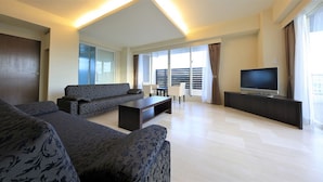 A modern living room with a sofa set, a coffee table, and a flat-screen TV on a stand. - Tatami no Yado Chatan Mihama by Coldio Premium (Chatan)