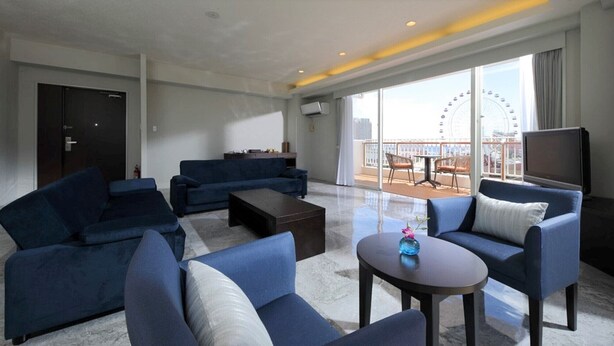 A modern living room with a large window, a sofa set, a coffee table, and a TV. - Tatami no Yado Chatan Mihama by Coldio Premium (Chatan)