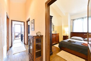 A bedroom with a wooden bed, a nightstand, a dresser, and a window with curtains. - Villa mit Pool in Kaštelir für 9 Personen (Kaštelir)