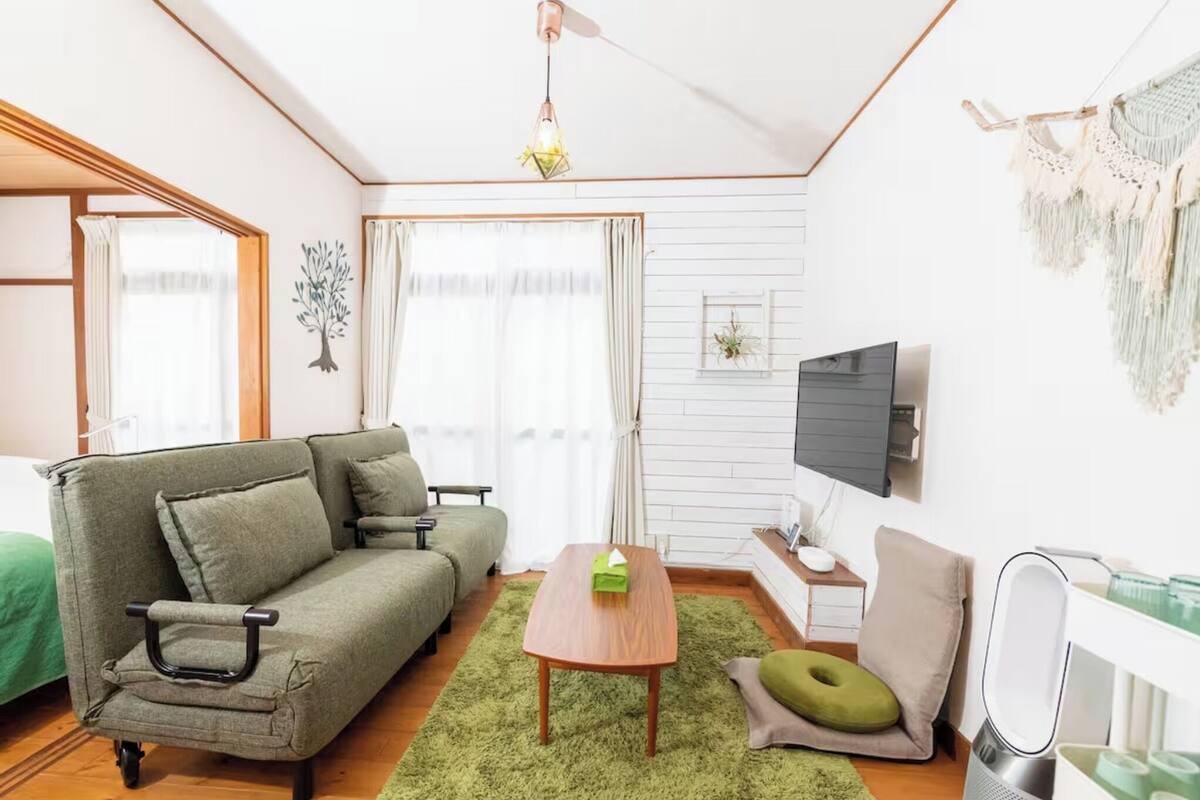 A cozy living room with a sofa, a coffee table, a TV, and a small side table.
