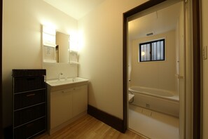 A bathroom with a sink, mirror, and bathtub. - Minakami Campground Riverstone (Minakami)