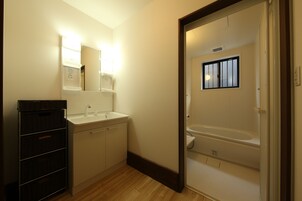 A bathroom with a sink, mirror, and bathtub.