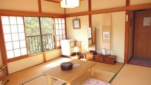 Et traditionelt japansk rum med tatamimåtter, et lavt bord, et skab og en skydedør.
