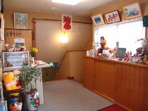 A room with a wooden desk, various stuffed toys, and a small plant. - Sea Side Pension Sakuraya (Shimoda)
