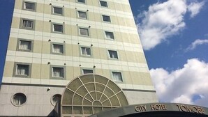 A tall hotel building with a modern design, featuring a large arched entrance and multiple windows. - City Hotel Tomobe (Kasama)