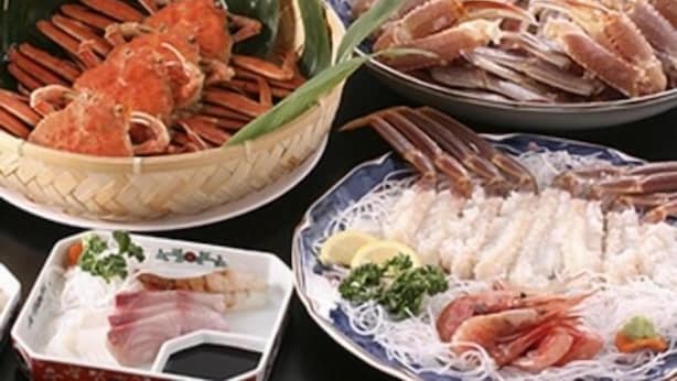 A variety of seafood dishes including crab, shrimp, and fish, served on a table. - Minshuku Taniwa (Kami)