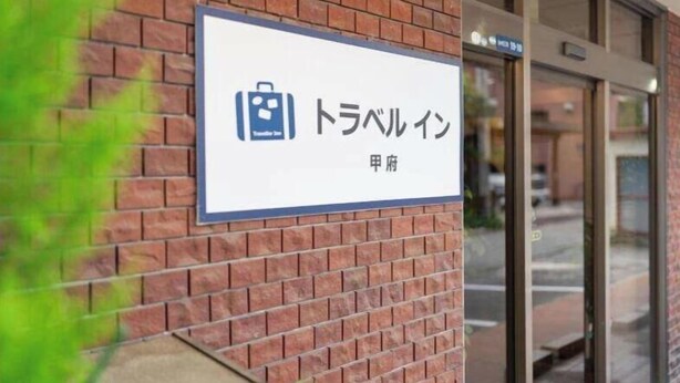 Een bord met Japanse tekst en een symbool van een koffer, dat een reisgerelateerde dienst of locatie aangeeft.