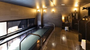 Un spa moderne doté d’une piscine chauffée, d’un sauna et d’un espace douche séparé.