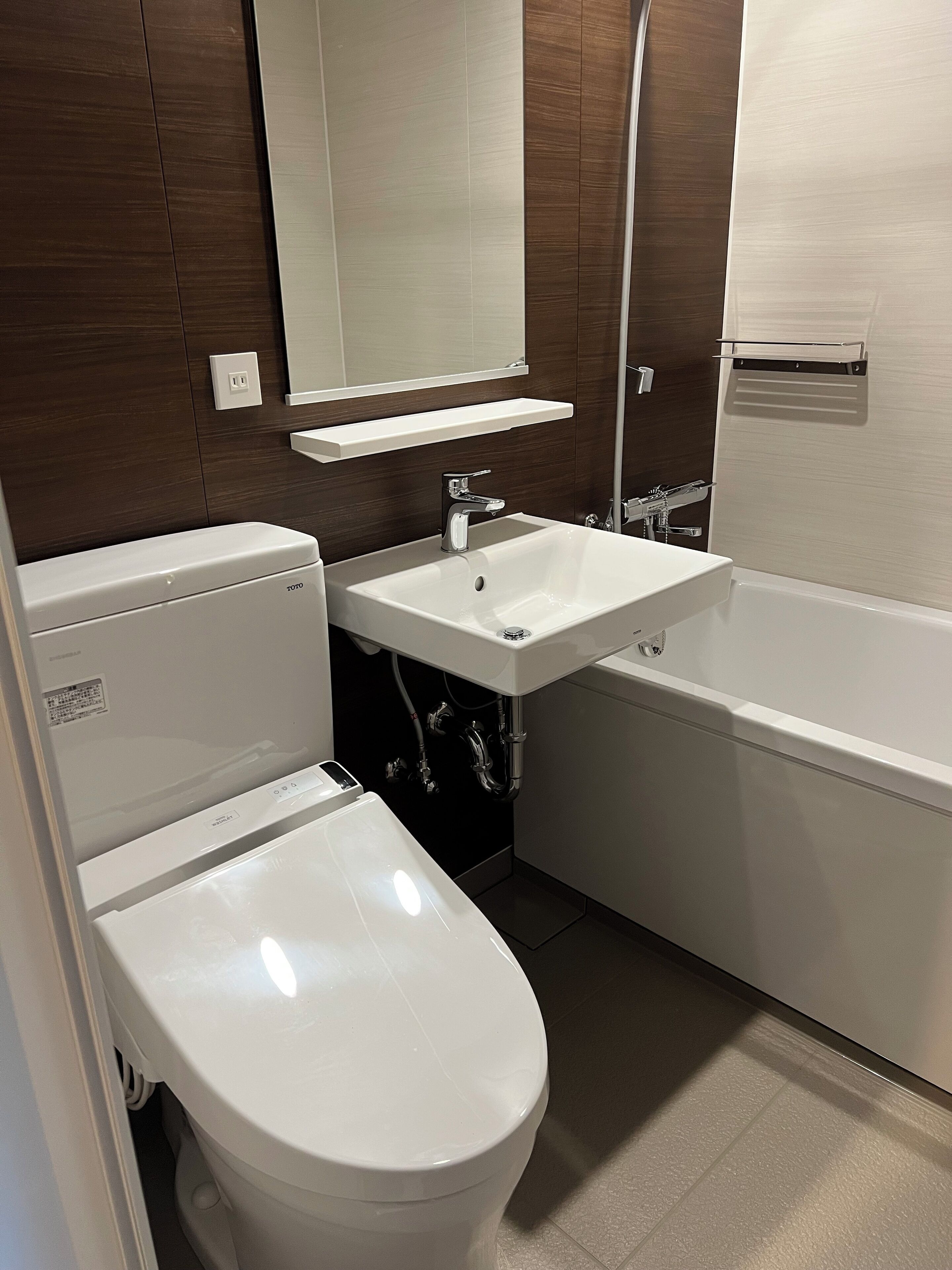 A modern bathroom with a white toilet, a sink, and a bathtub.