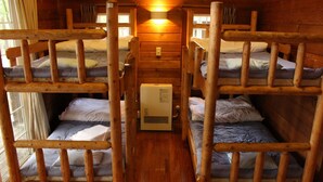 Eine Holzhütte mit Etagenbetten und einem zentralen Heizkörper.