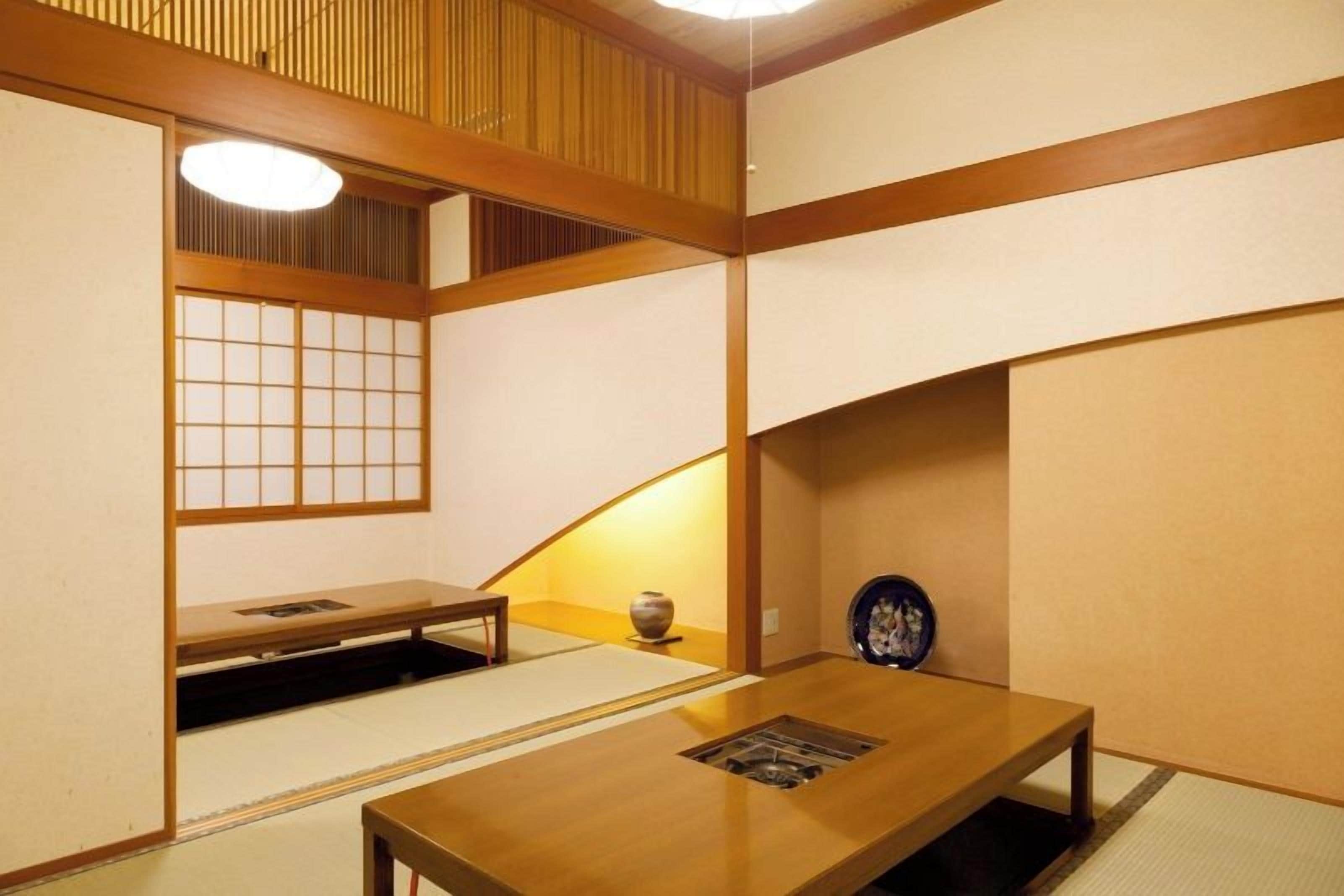 Una habitación japonesa tradicional con suelo de tatami, una mesa de madera baja y un celosía de papel shoji.