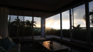 A modern room with large windows, a sofa, and a coffee table. - Ryukyu Ritei Ingya (Miyakojima)