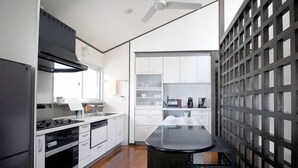 A modern kitchen with white cabinetry, a black countertop, and a built-in stove. - Pontoon <ishigakijima> (Ishigaki)