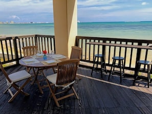 A wooden deck with a table set for dining, overlooking a turquoise sea. - Pontoon <ishigakijima> (Ishigaki)