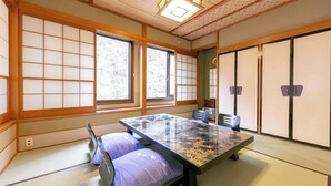 A traditional Japanese-style room with tatami flooring, a low table, and shoji screens. - Kawaji Onsen Ichiryukaku (Nikko)