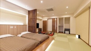 A hotel room with two beds, a TV, a desk, and a wardrobe. - Kawaji Onsen Ichiryukaku (Nikko)