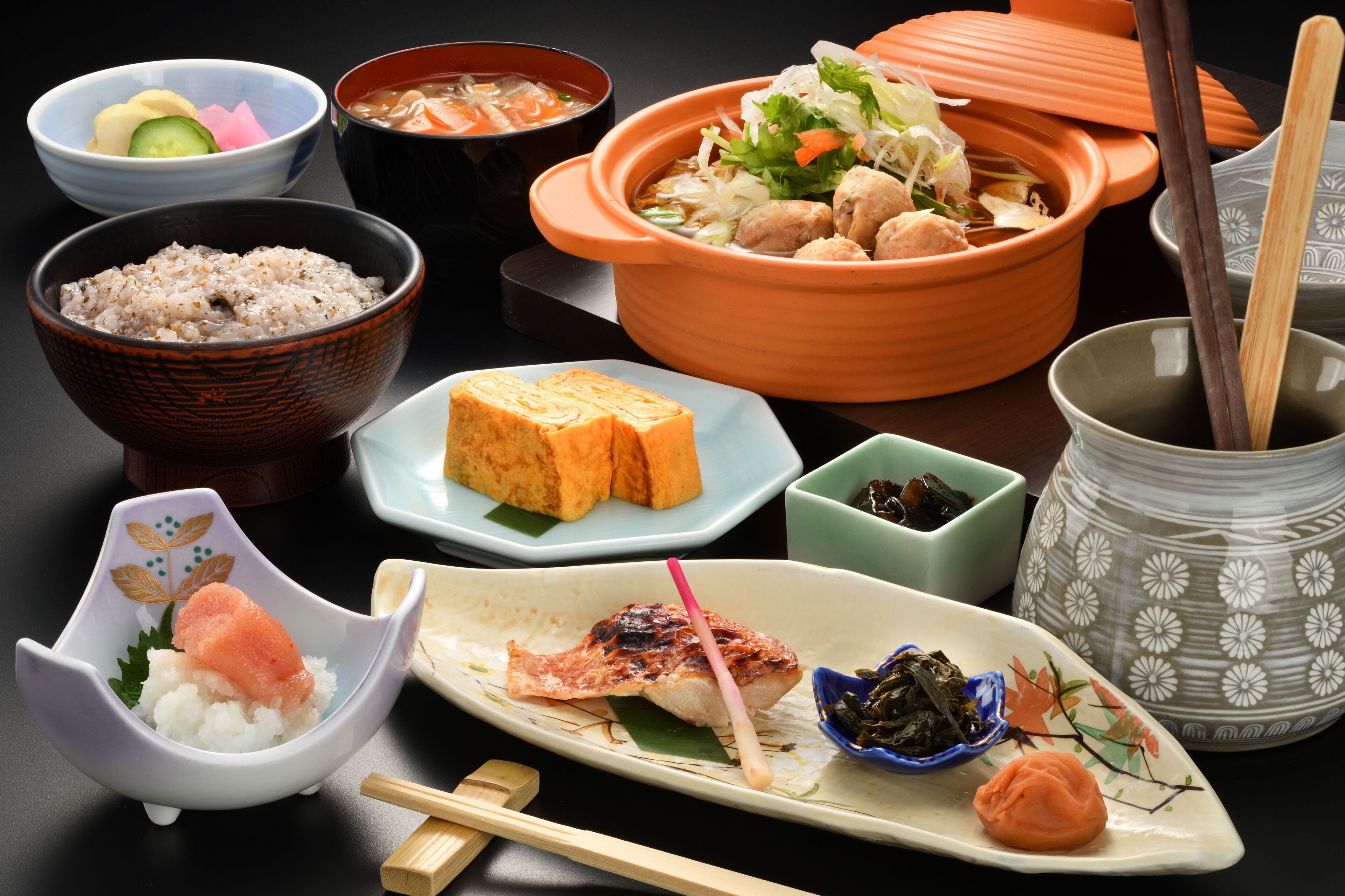 Diversos pratos japoneses, incluindo sushi, arroz e sopa.