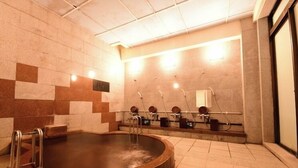 Un espace spa comprenant un jacuzzi, plusieurs lavabos et un sol carrelé.
