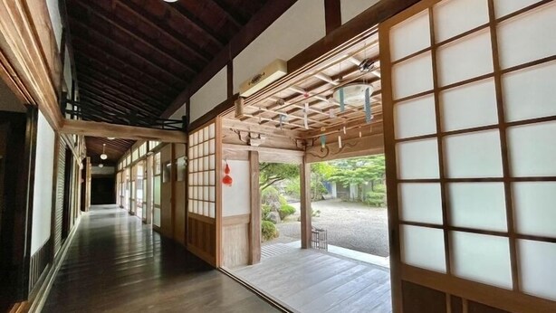 Un couloir japonais traditionnel, avec un plancher en bois et des portes coulissantes.