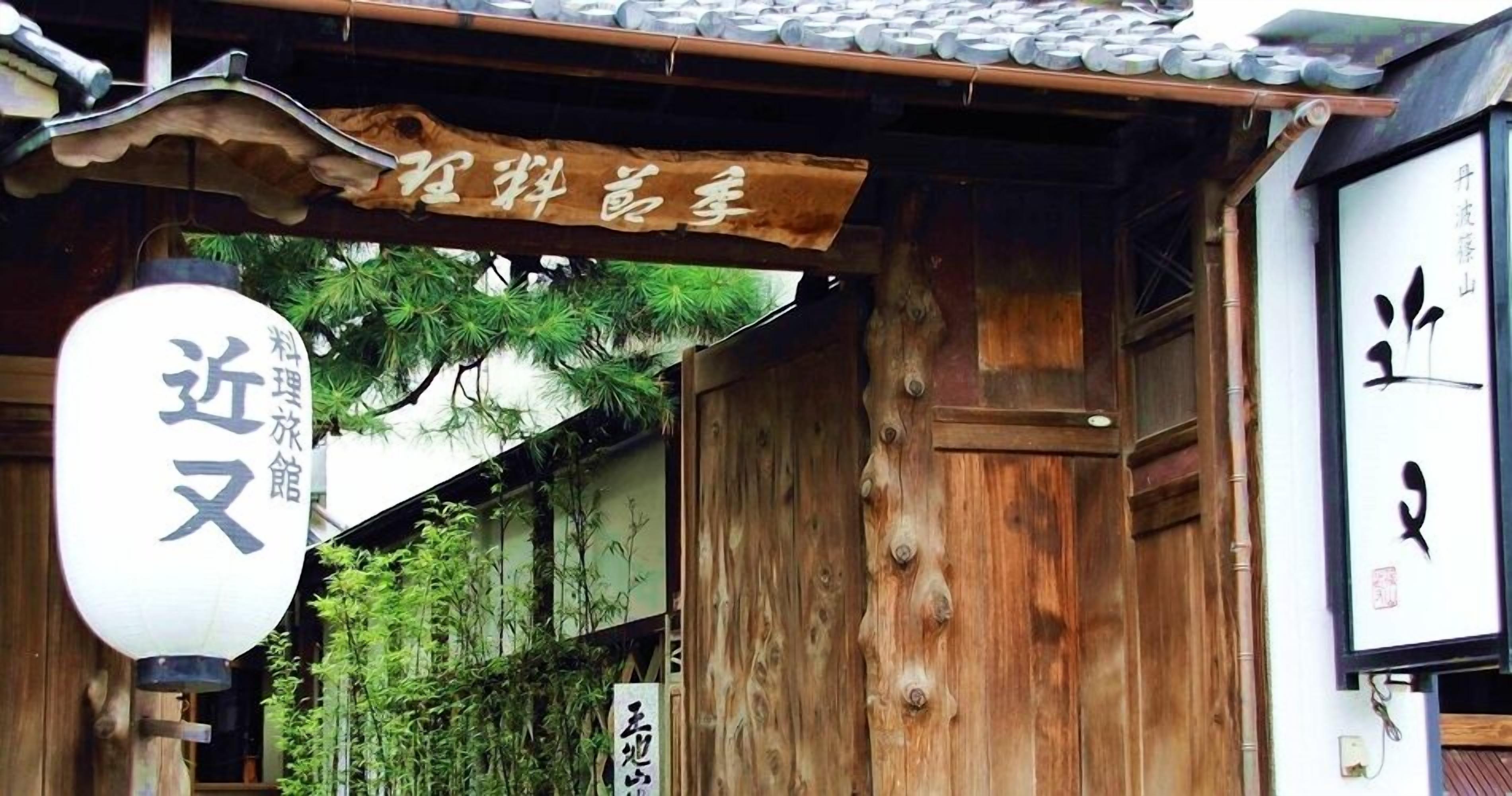 Un bâtiment japonais traditionnel, avec une façade en bois et une enseigne au-dessus de l’entrée.