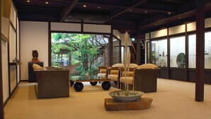 A traditional Japanese-style room with tatami flooring, a low table with a bowl and chopsticks, and a large window with a view of greenery. - Tanba Sasayama Kinmata (Sasayama)
