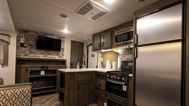 A compact kitchen with a stove, microwave, and refrigerator. - The Trailerhouse Village Yobuko Seaside (Karatsu)