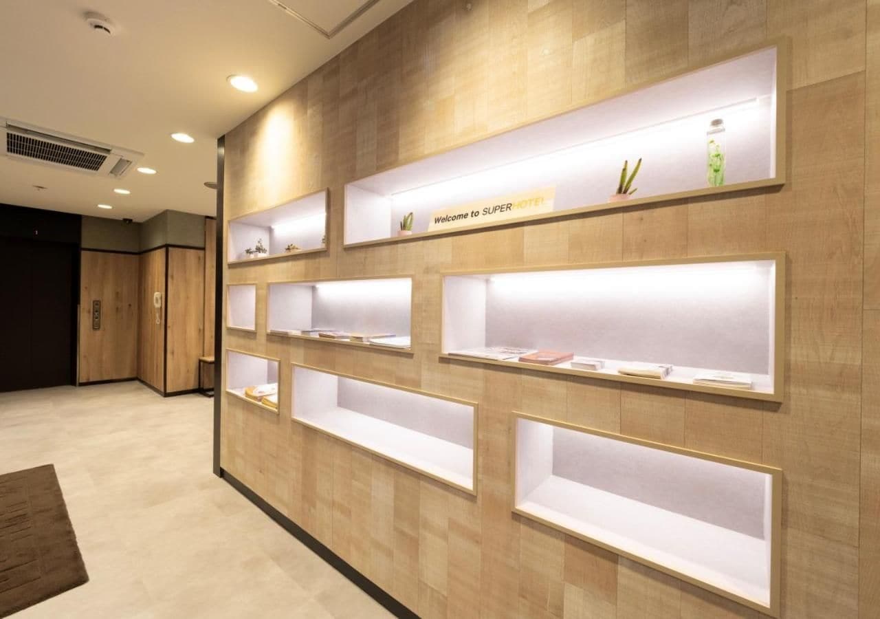 A reception area with wooden paneling and multiple illuminated display shelves.