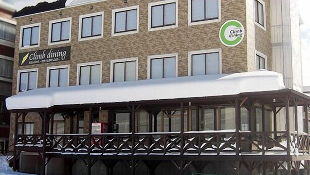 A building with a sign reading "Climb dining" and a logo indicating it's a climbing center. - Guest House Climb Dining (Yuzawa)