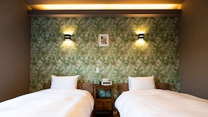 A hotel room with two beds, a nightstand, and a wall with a tropical leaf pattern. - Alezed Villa Shiraho <ishigakijima> (Ishigaki)