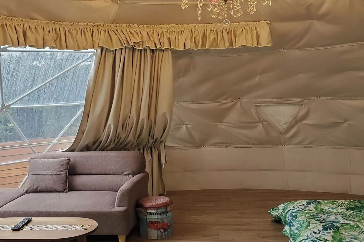 Een gezellige kamer met een bank, een klein tafeltje en een kamerkleed met patroon.