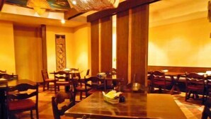A restaurant with wooden tables and chairs, a patterned floor, and a decorative ceiling. - Hotel Takako (Aizuwakamatsu)
