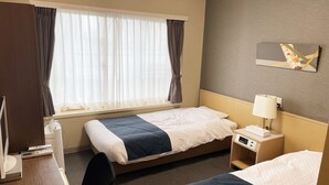 A hotel room with two beds, a desk with a telephone, a lamp, and a small bedside table with a clock. - Hotel Takako (Aizuwakamatsu)
