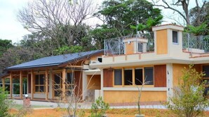 A two-story building with a wooden exterior and a balcony. - Izumibaru House (Nakijin)
