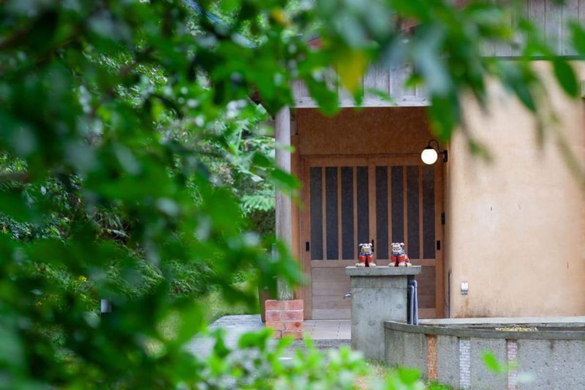 Ein Gebäude mit einer Holztür und zwei kleinen Statuen auf einem Gesims.