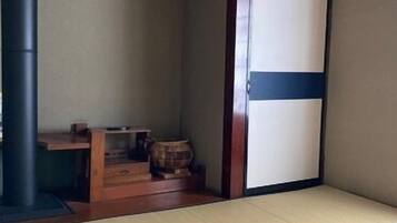 A tatami mat room with a sliding door, a wooden table, and a barrel.