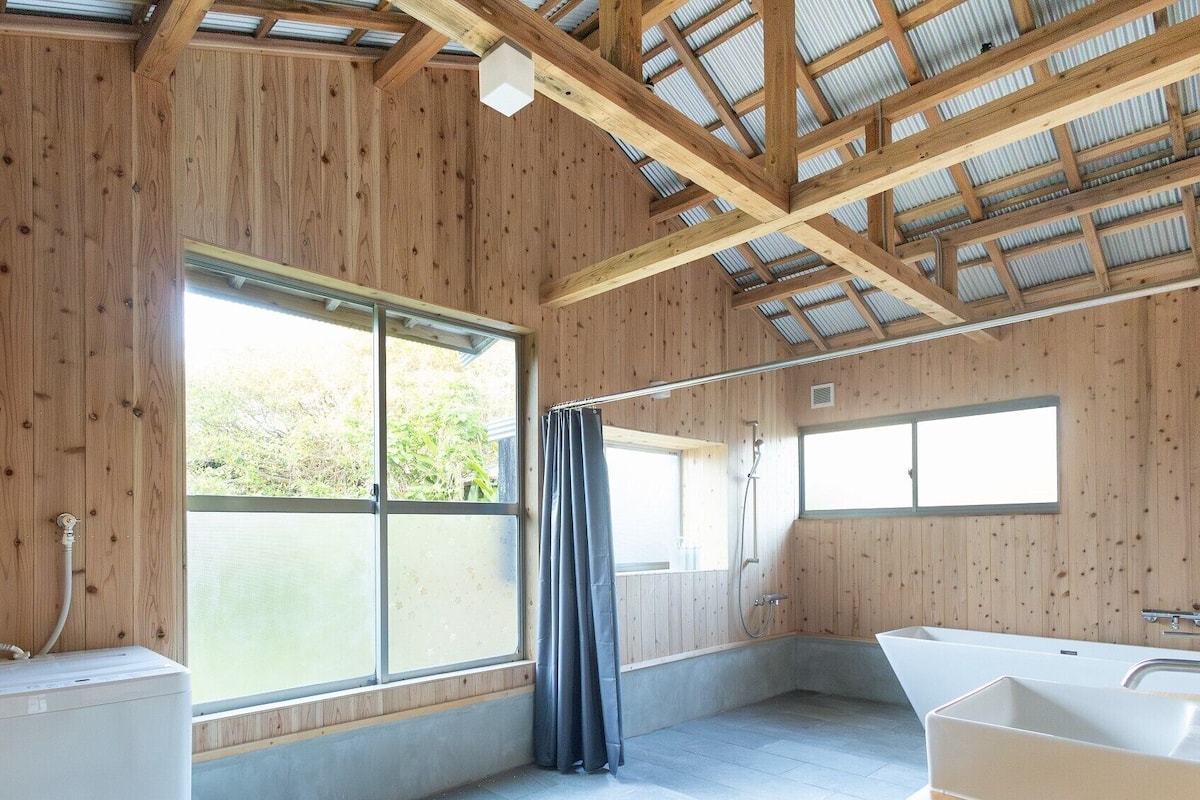 Eine Holzhütte mit einem großen Fenster, einer Dusche und einer Badewanne.