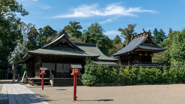 A traditional Japanese building with a sloped roof and wooden construction, surrounded by greenery. - Super Hotel Saitama Kuki (Kuki)