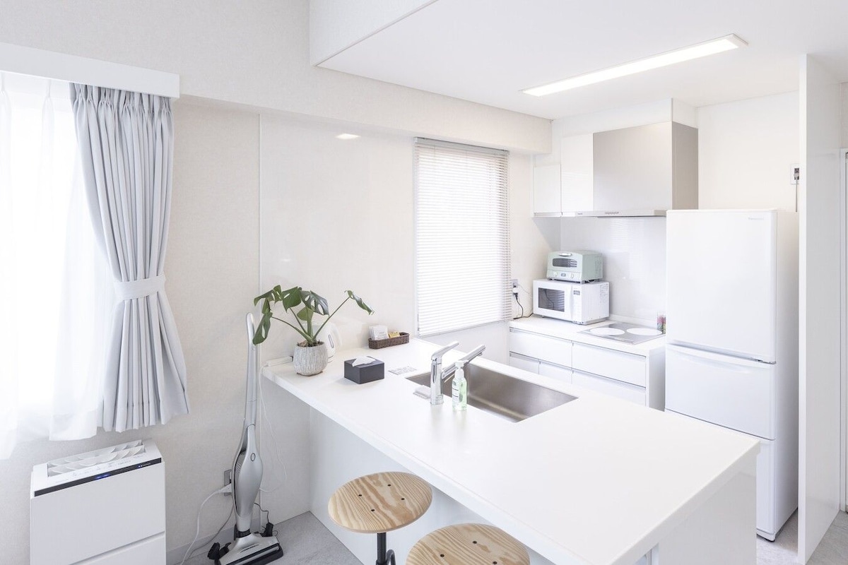 A modern kitchen with white cabinetry, a built-in microwave, and a sink.