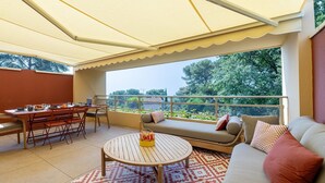 A balcony with a dining area, a sofa, and a patterned rug. - Sea-View Duplex for Family (Villeneuve-Loubet)